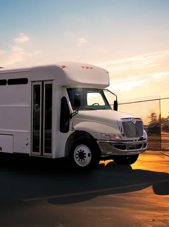 White shuttle bus parked next to a security fence at a prison near Denver
